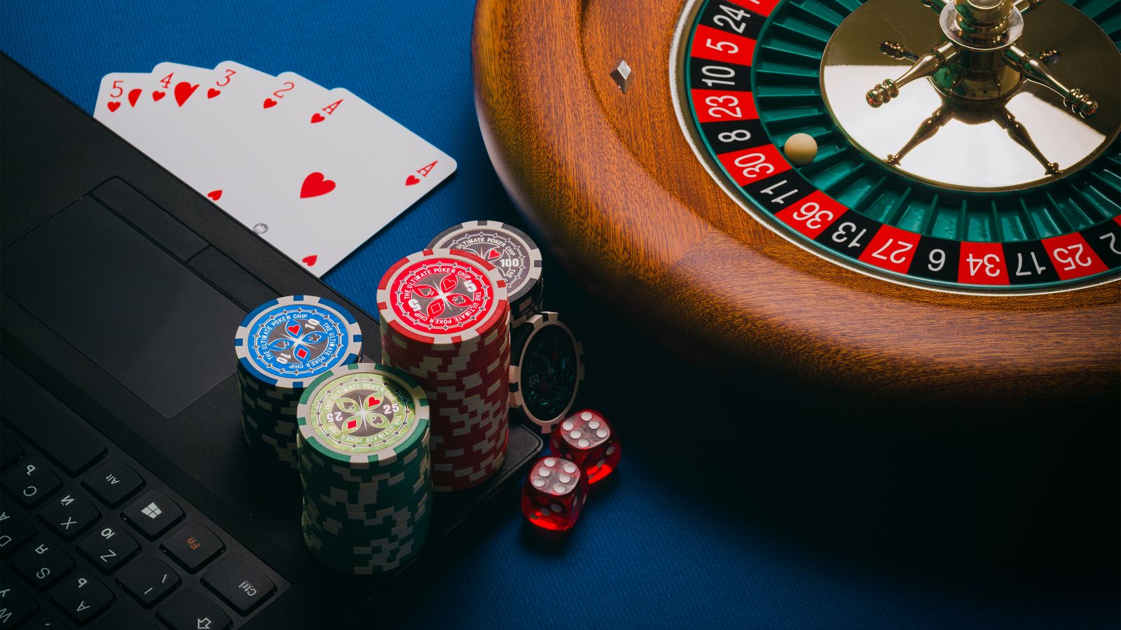 Laptop with playing cards and roulette wheel